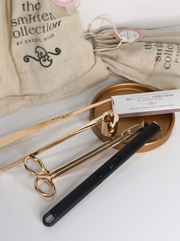 Level up your candle enjoyment with this elegant candle accessory kit in gold. It includes a wick trimmer, wick snuffer, wick dipper, a black rechargeable USB lighter and a box of long matchsticks. Comes in a reusable jute bag.